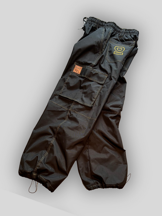 Side view of Black Jean style pants with a brand logo on a light gray background