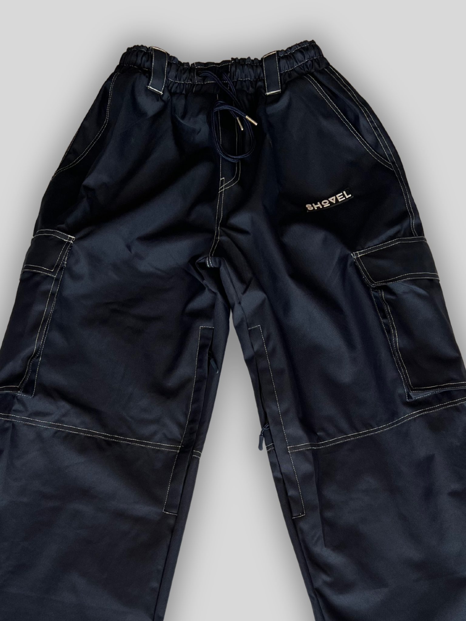 Blue Jean style ski and snowboard pants with logo. Close up front view with gray background