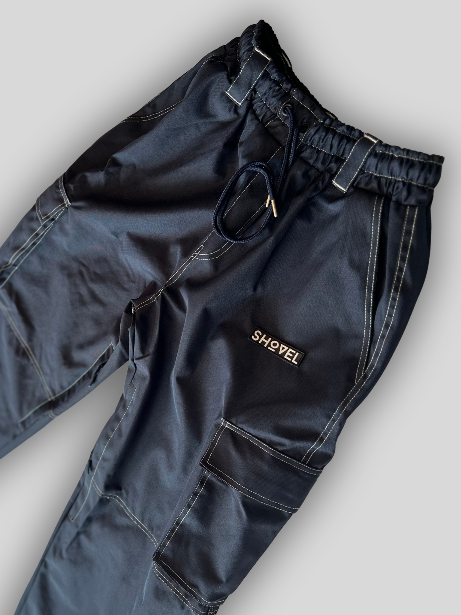 Dark blue pants with a visible brand logo on a light gray background