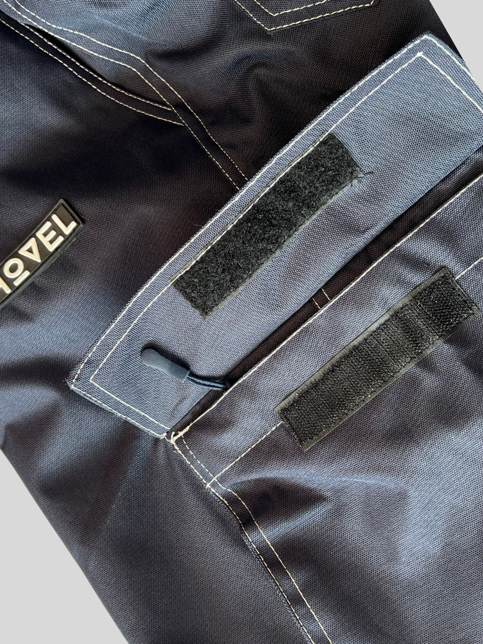 Close-up view of side pocket on blue jeans style skin Snowboard pants with shovel logo showing.