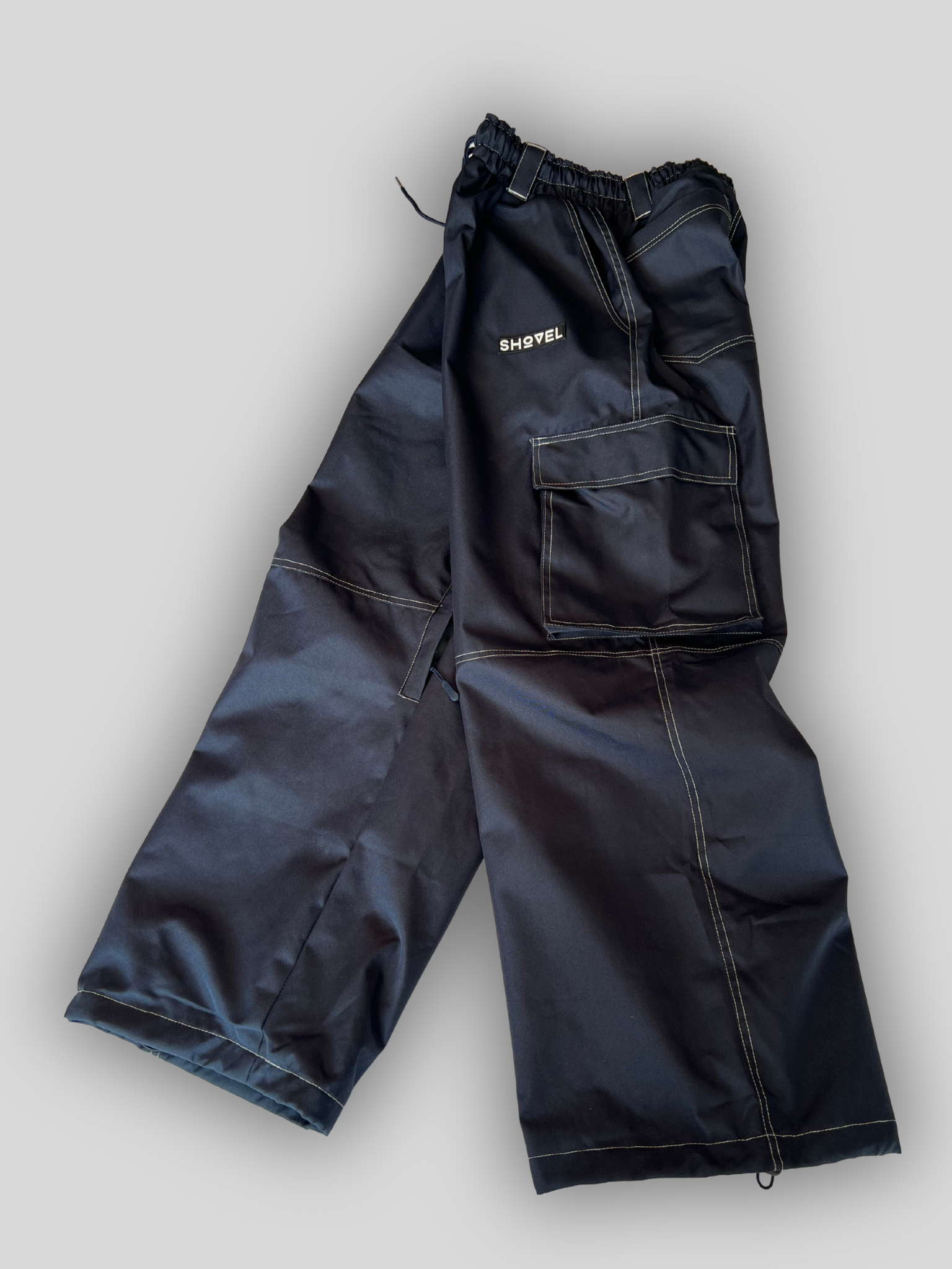 Blue Jean style ski and snowboard pants with logo. Side view with gray background