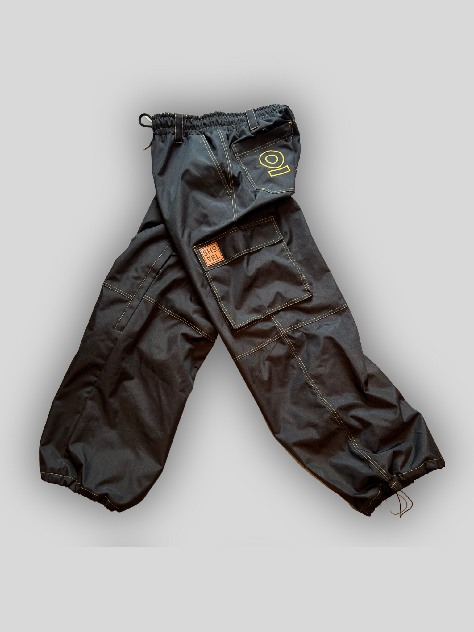 Side view of Black Jean style pants with a brand logo on a light gray background